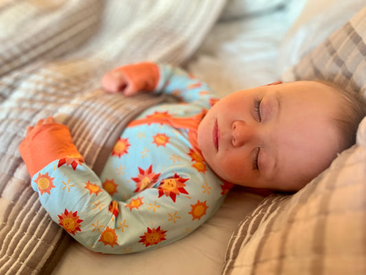 Baby sleeping in pajamas with sun print