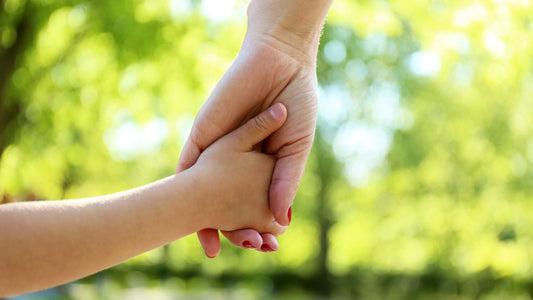 A child and parent holding hands