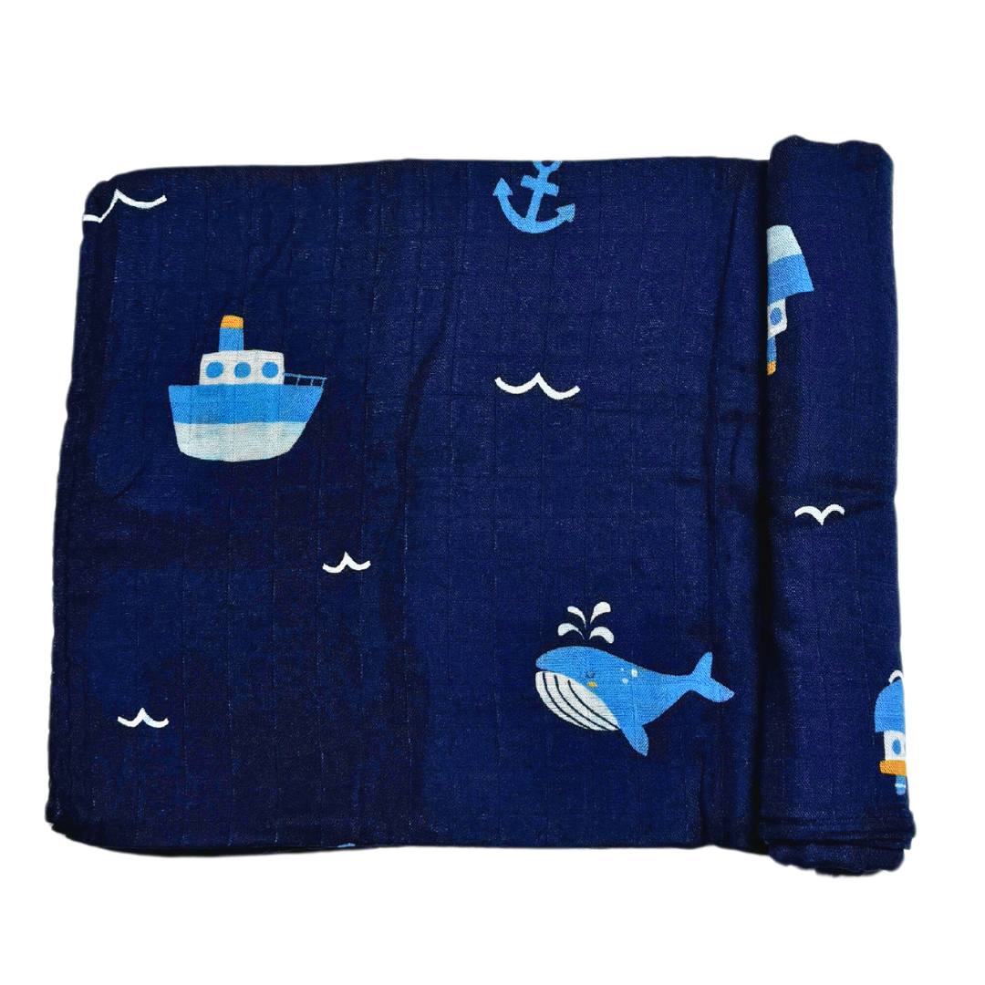 Swaddle blanket with whale and tugboat pattern print.