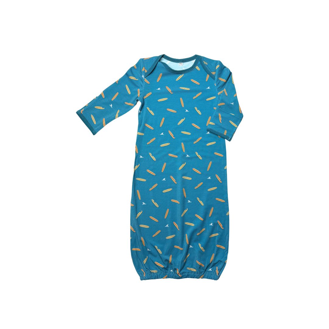 Baby gown with surfboards and shark fin pattern on blue background 